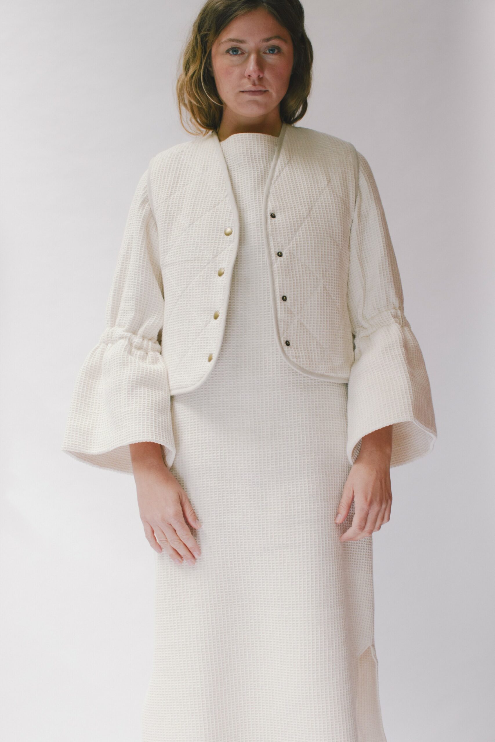 Waffelstrukturkleid in Creme aus 100 % Baumwolle, handgefertigt, mit raffinierten Ärmeln und seitlichen Schlitzen.