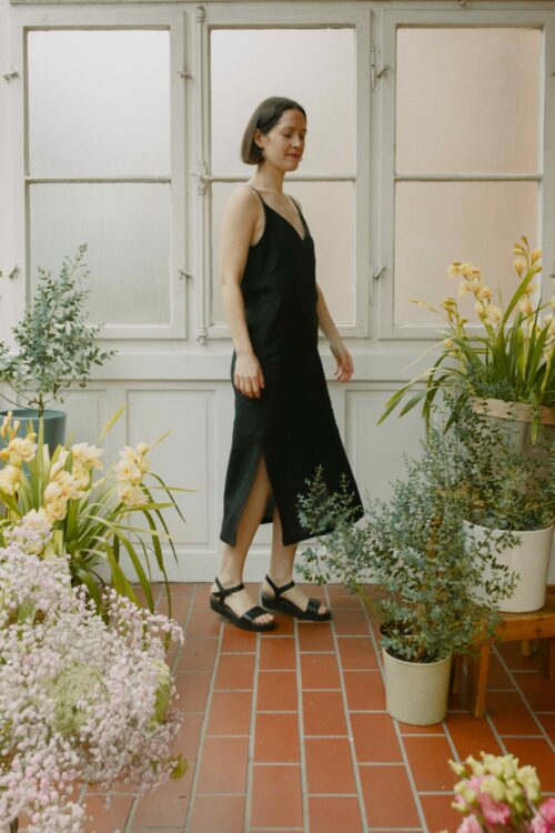 Leinenkleid in Schwarz aus 100 % niederländischem Leinen, Trägerkleid mit Vorder- und Rückenausschnitt, Seitenschlitzen und seitlichen Eingriffstaschen.