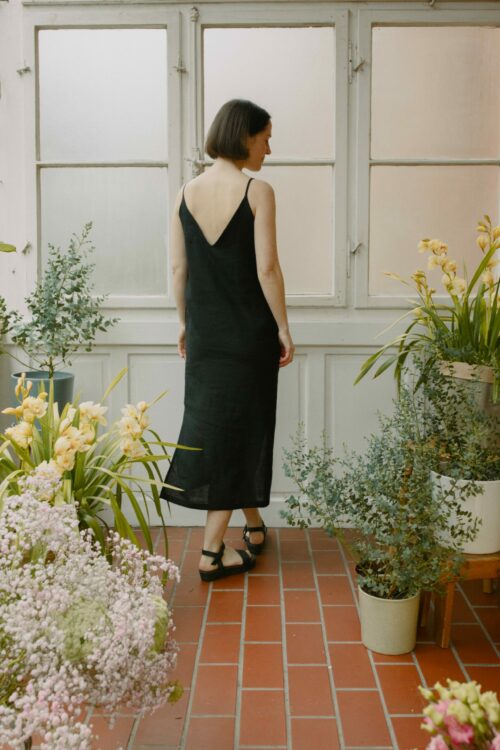 Leinenkleid in Schwarz aus 100 % niederländischem Leinen, Trägerkleid mit Vorder- und Rückenausschnitt, Seitenschlitzen und seitlichen Eingriffstaschen.