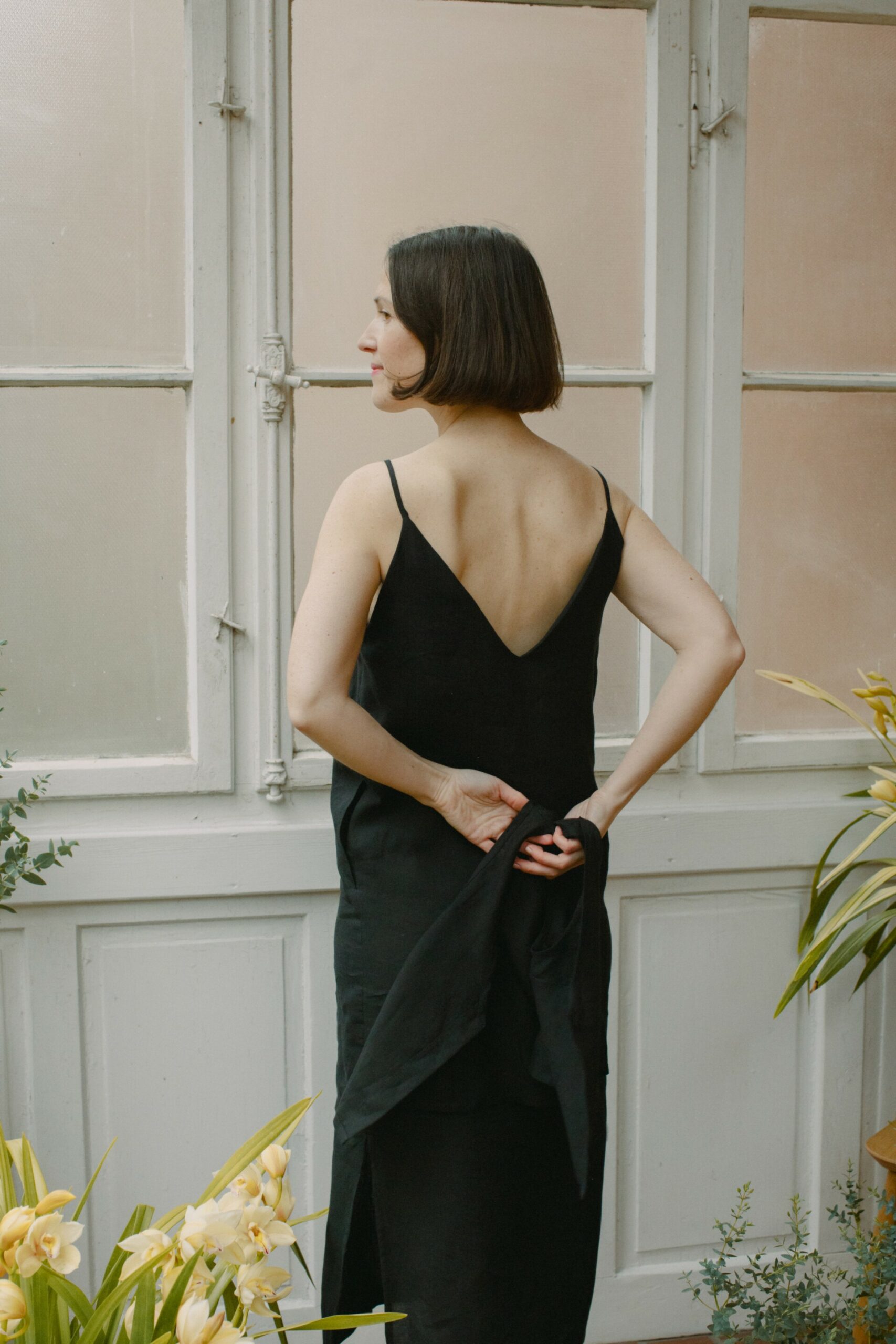 Leinenkleid in Schwarz aus 100 % niederländischem Leinen, Trägerkleid mit Vorder- und Rückenausschnitt, Seitenschlitzen und seitlichen Eingriffstaschen.