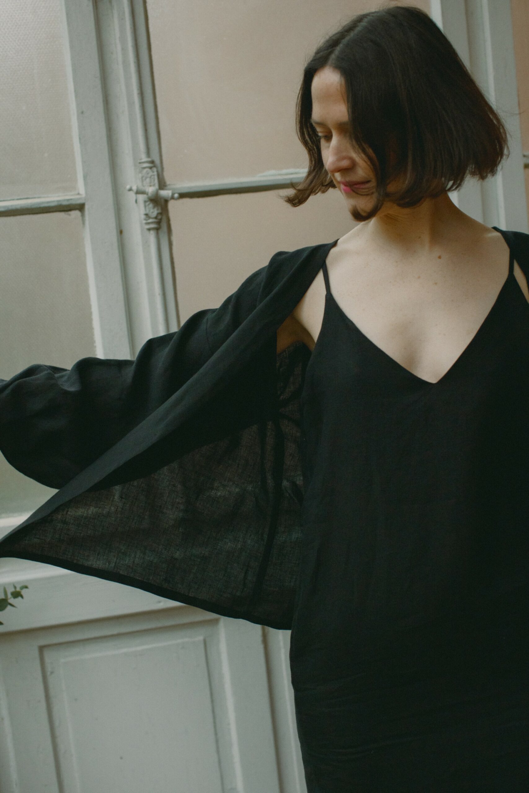 Leinenkleid in Schwarz aus 100 % niederländischem Leinen, Trägerkleid mit Vorder- und Rückenausschnitt, Seitenschlitzen und seitlichen Eingriffstaschen.