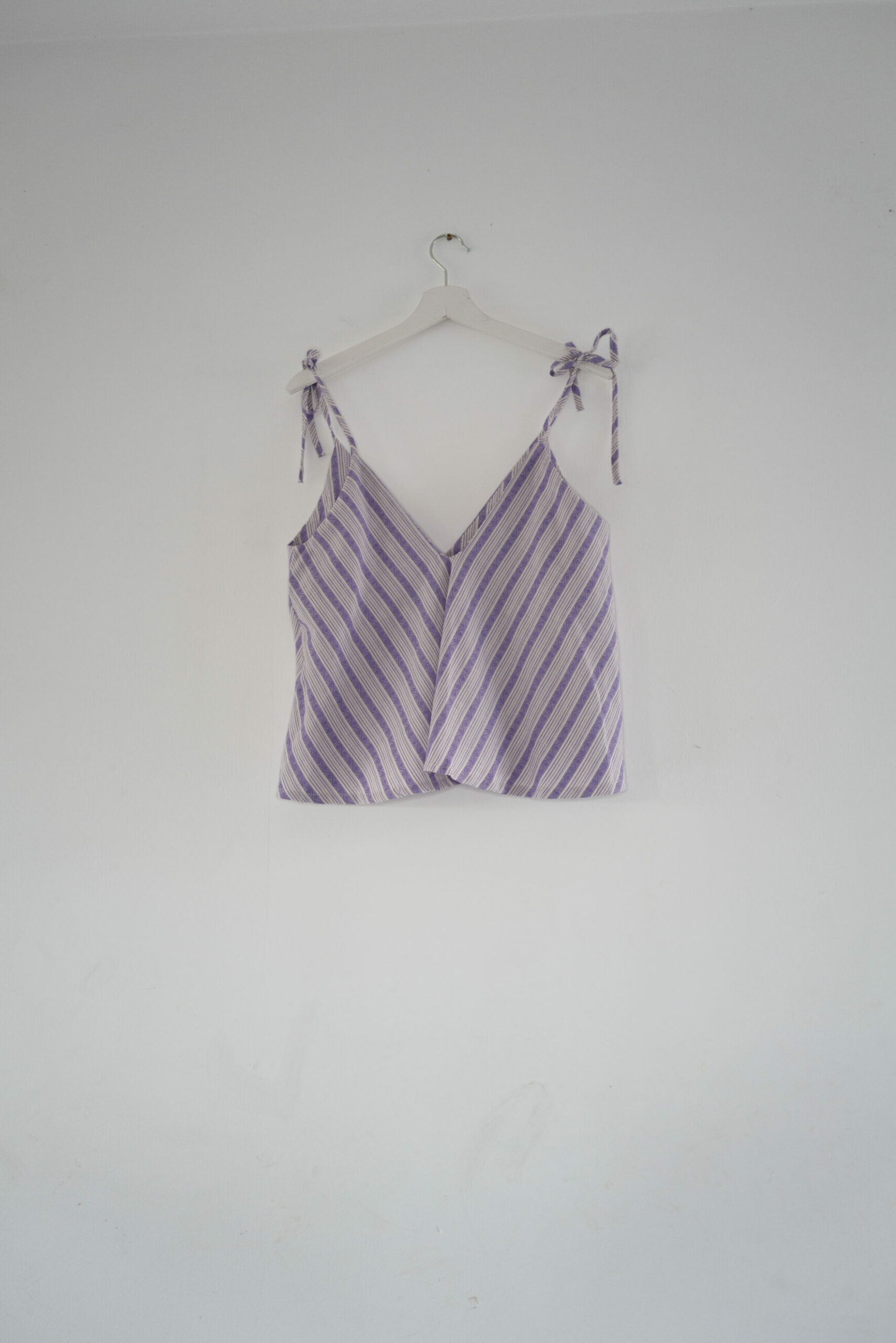 Bindetop Flieder/Wiese – Handgefertigt aus 100 % Baumwolle, leicht und verstellbar Bindetop in Flieder/Wiese, handgefertigt aus 100 % Baumwolle, mit weitem Schnitt und verstellbarem V-Ausschnitt.